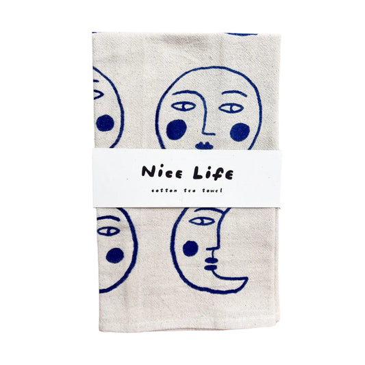 Two cotton tea towels with face designs on a wooden surface, branded 'Nice Life'.