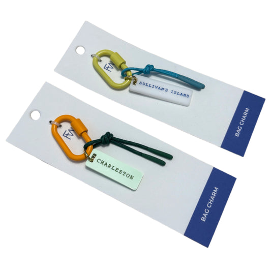 Two keychains on display cards with visible branding on a wooden surface.