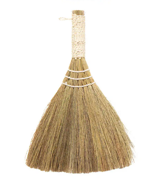 Traditional broom with a straw handle on a white background